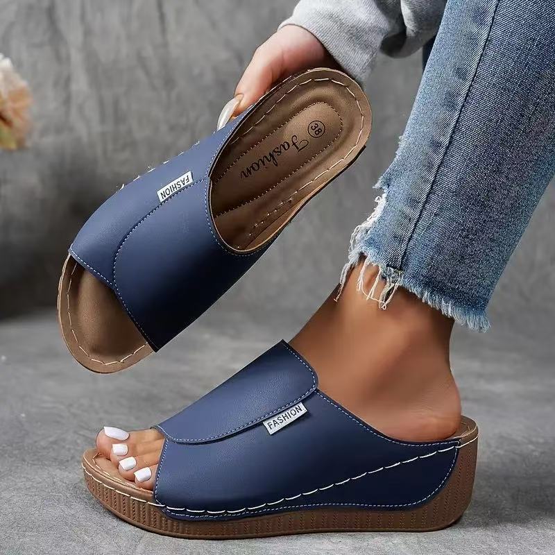 Close-up of the cushioned footbed and arch support on casual summer wedge sandals.