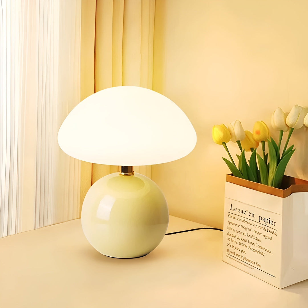 Yellow mushroom LED table lamp placed on a desk next to flowers