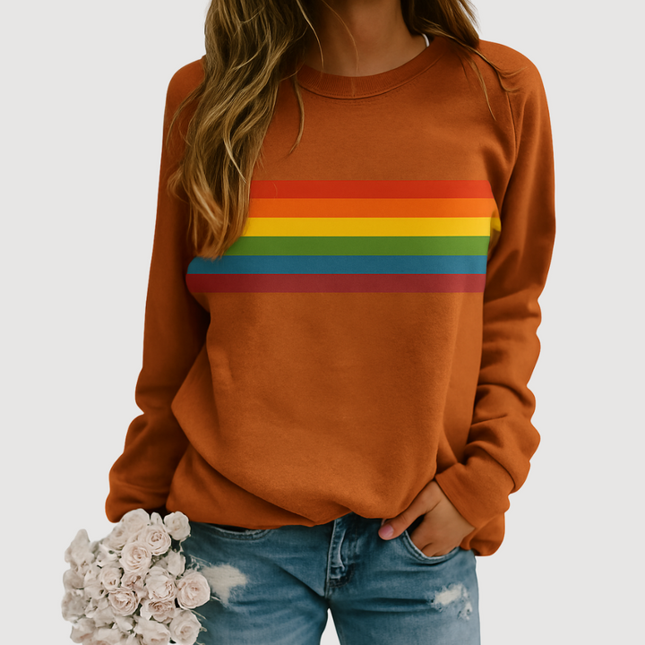 Woman wearing khaki orange rainbow stripe crewneck sweatshirt holding flowers