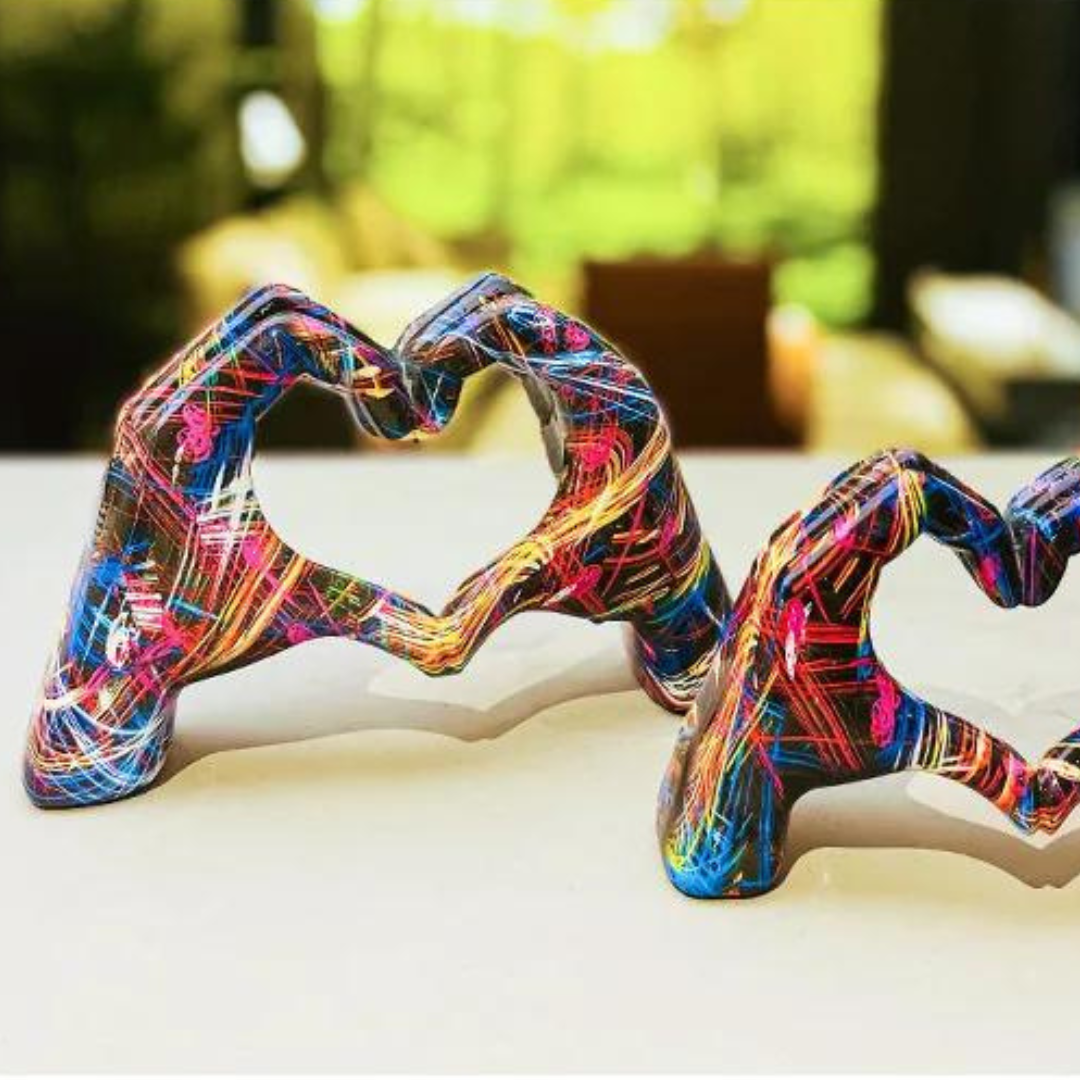 Two different sized colourful hand art sculptures displayed together