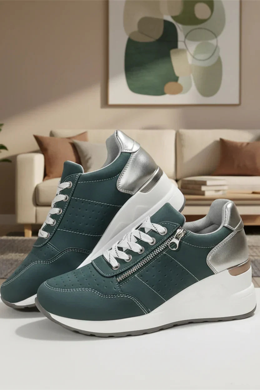 Green orthopaedic walking sneakers displayed indoors with a decorative painting in the background