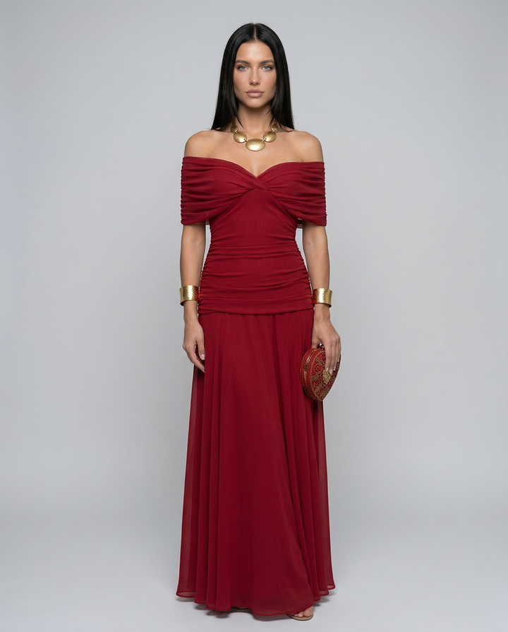 Full-length front view of a woman standing in a red off shoulder evening maxi dress