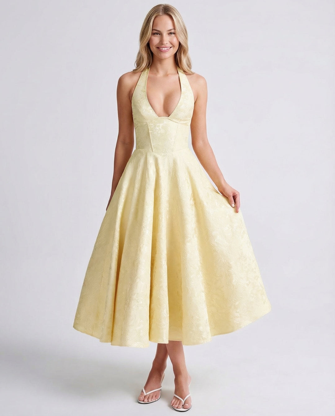 Front view of a model wearing a yellow vintage halter midi dress