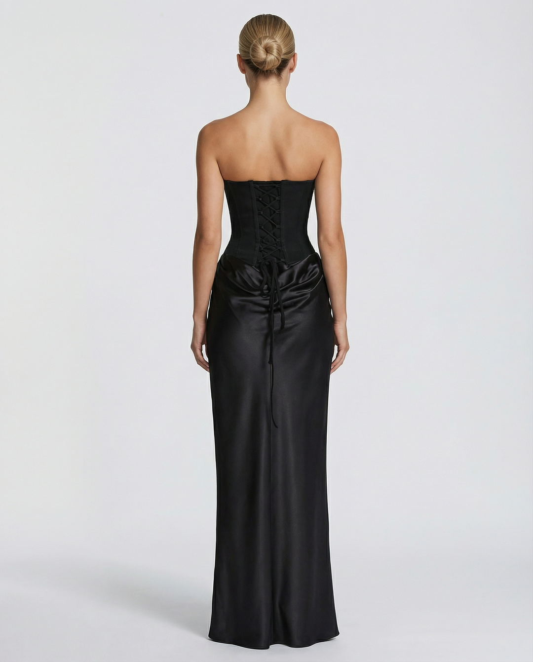 Back view of model showcasing the lace-up corset detail and flowing skirt of the Vivienne dress