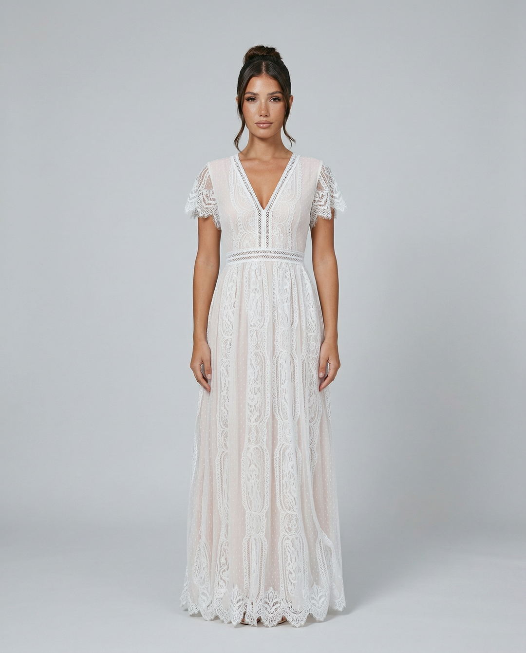 Front view of a woman wearing an elegant white lace maxi dress with short sleeves and a V-neckline.