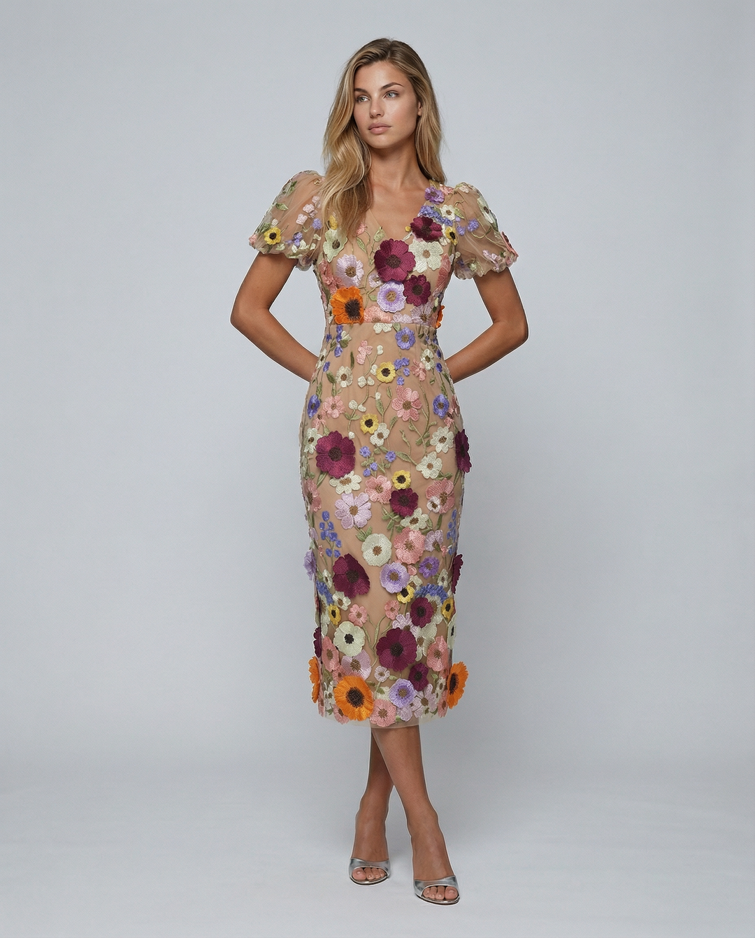 Front view of a woman wearing a floral embroidered midi dress with short puff sleeves