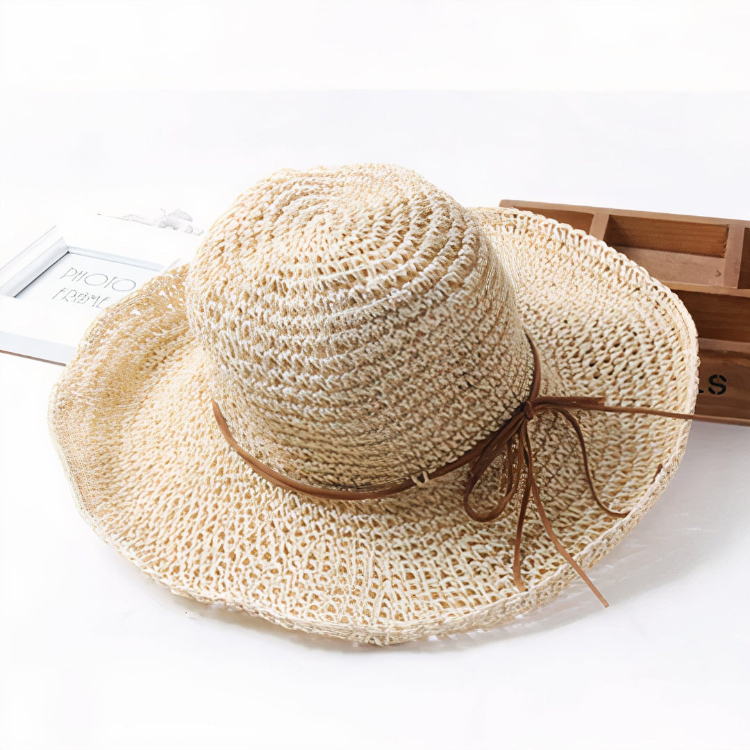 Elegant beige beach hat with wide brim folded for packing in travel bags