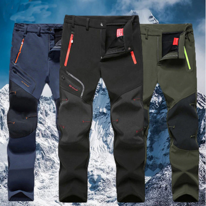 Three men's winter lined waterproof trousers in black, blue, and green displayed against a snowy mountain background.