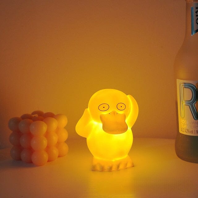 Psyduck LED night light casting a warm and soft ambient glow next to a candle