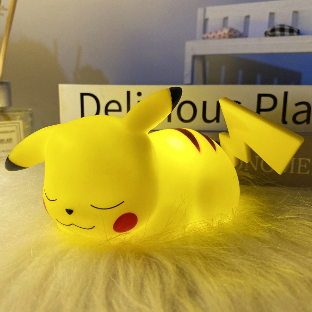 Sleeping Pikachu character LED bedside lamp resting on a fluffy white surface