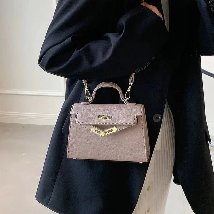 Brown women's stylish shoulder bag worn over the shoulder with a dark blazer