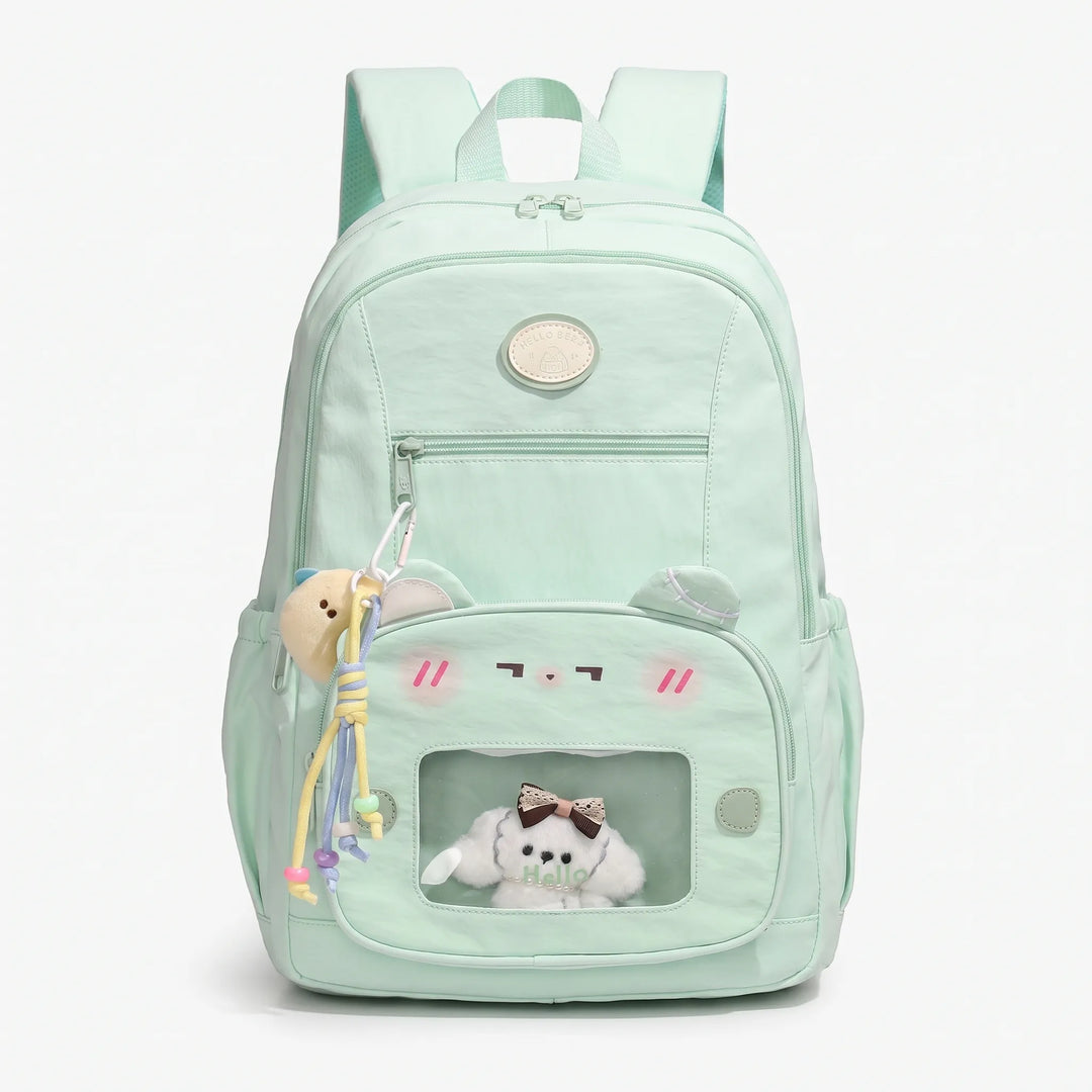 Front studio view of the light green preppy daypack featuring a clear display window and charms