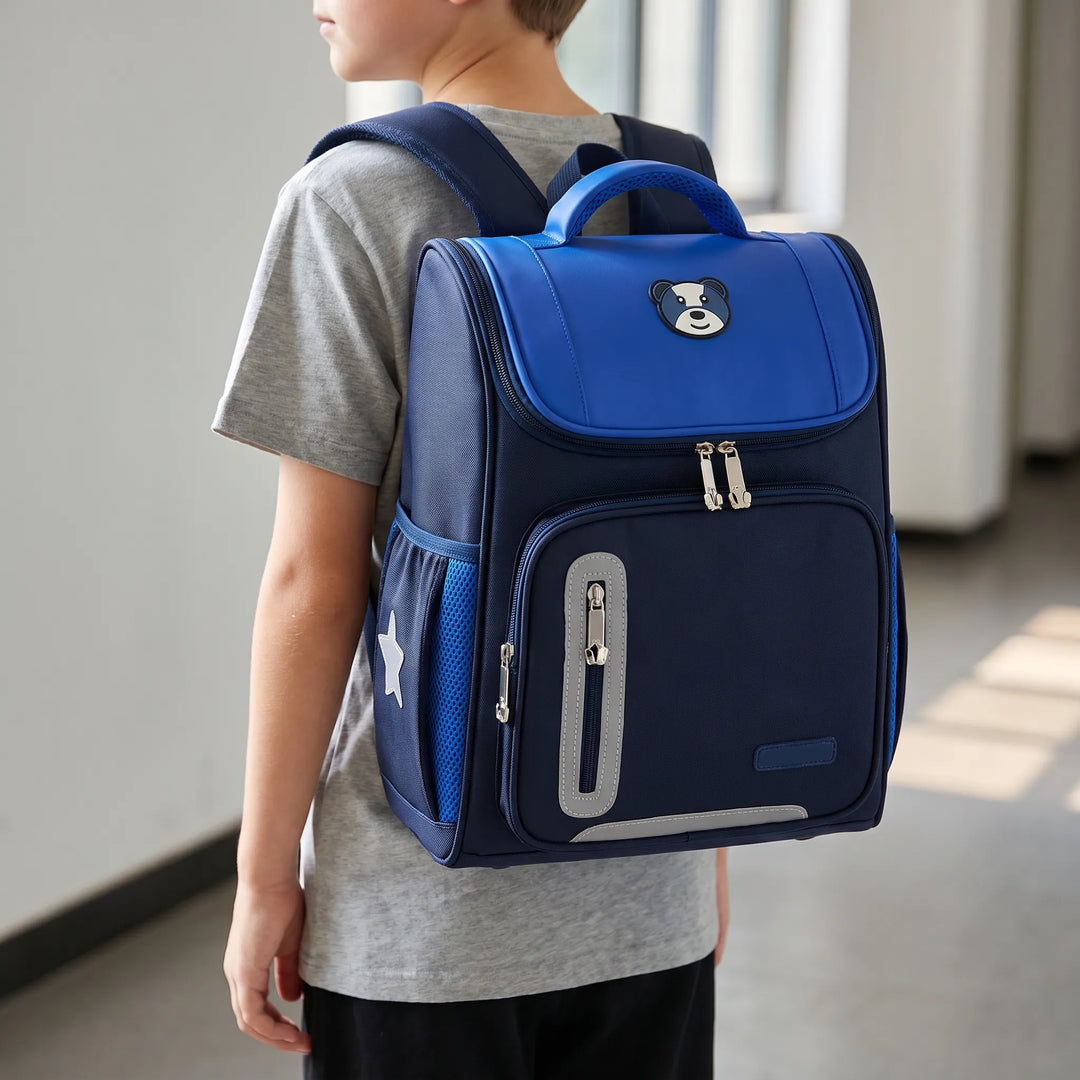 Child wearing the navy blue primary school backpack with bear design
