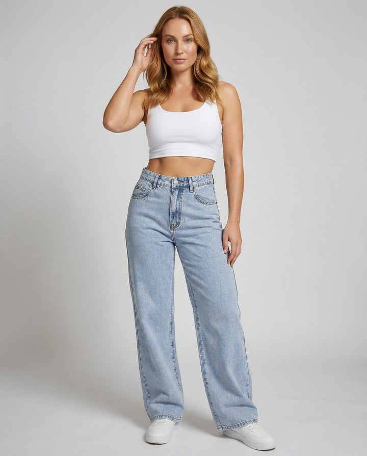 Model wearing women's high-waisted flared jeans and white crop top front view