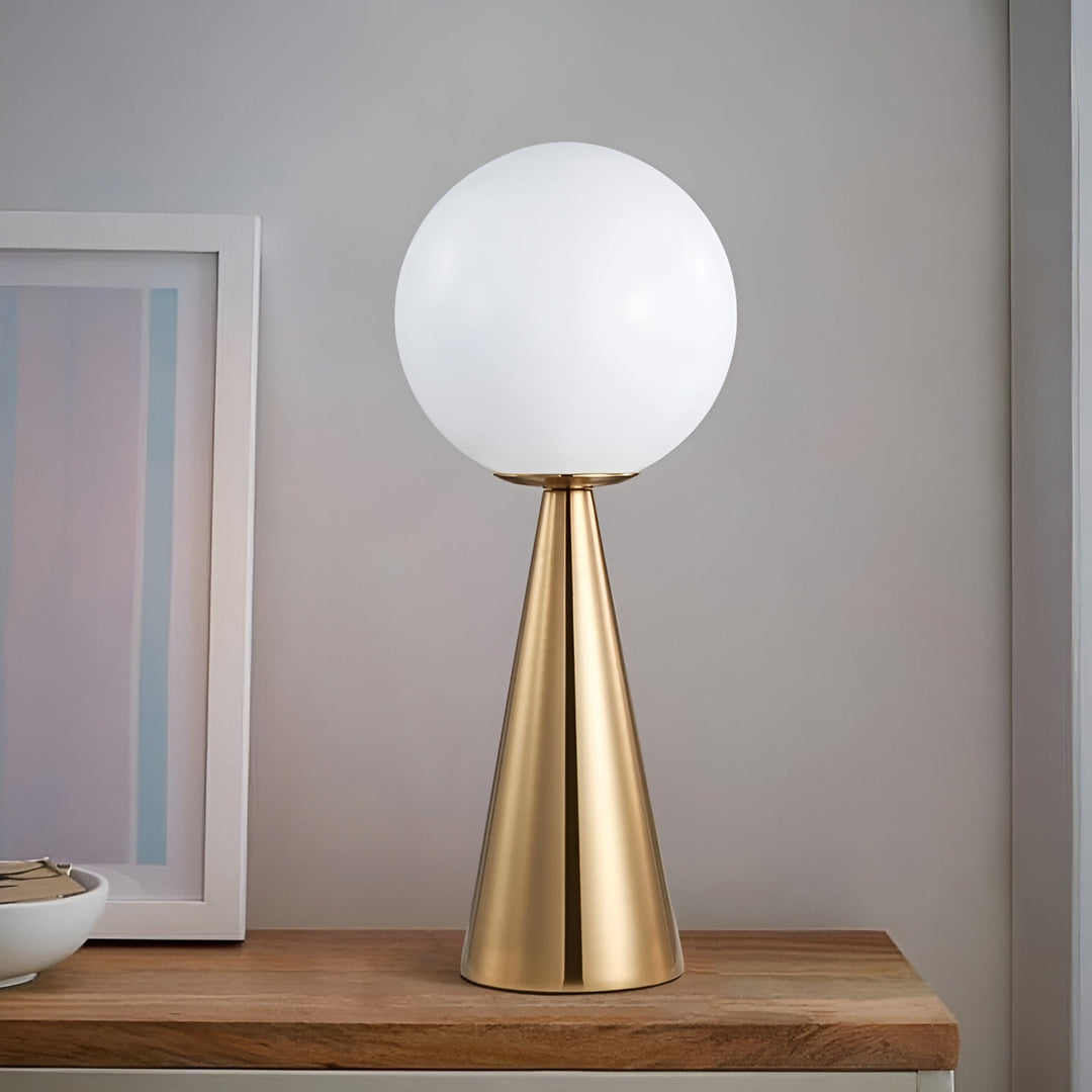 Modern gold table lamp with white glass globe on wooden surface