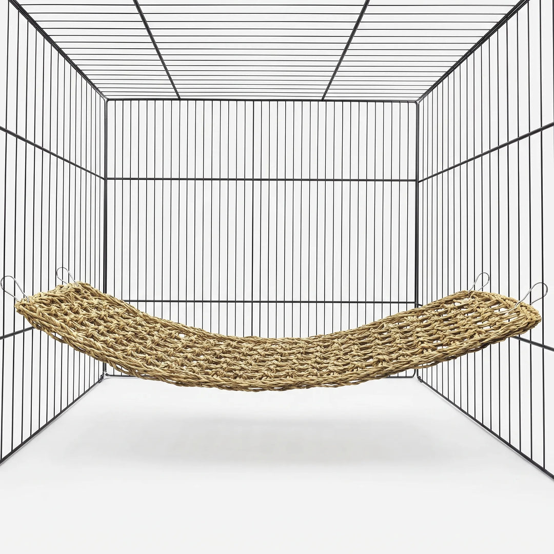 Rectangular woven seagrass bird hammock installed inside a wire cage