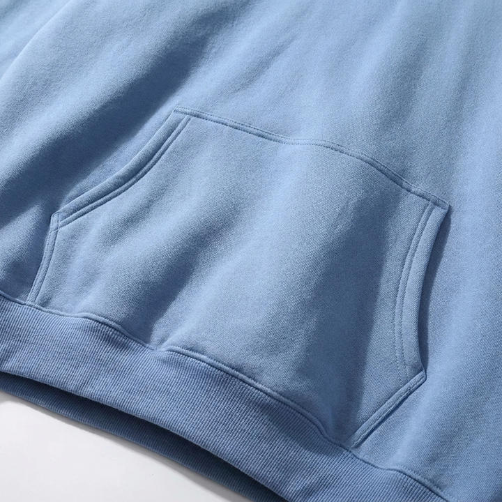Close-up of front kangaroo pocket and ribbed hem on light blue hoodie