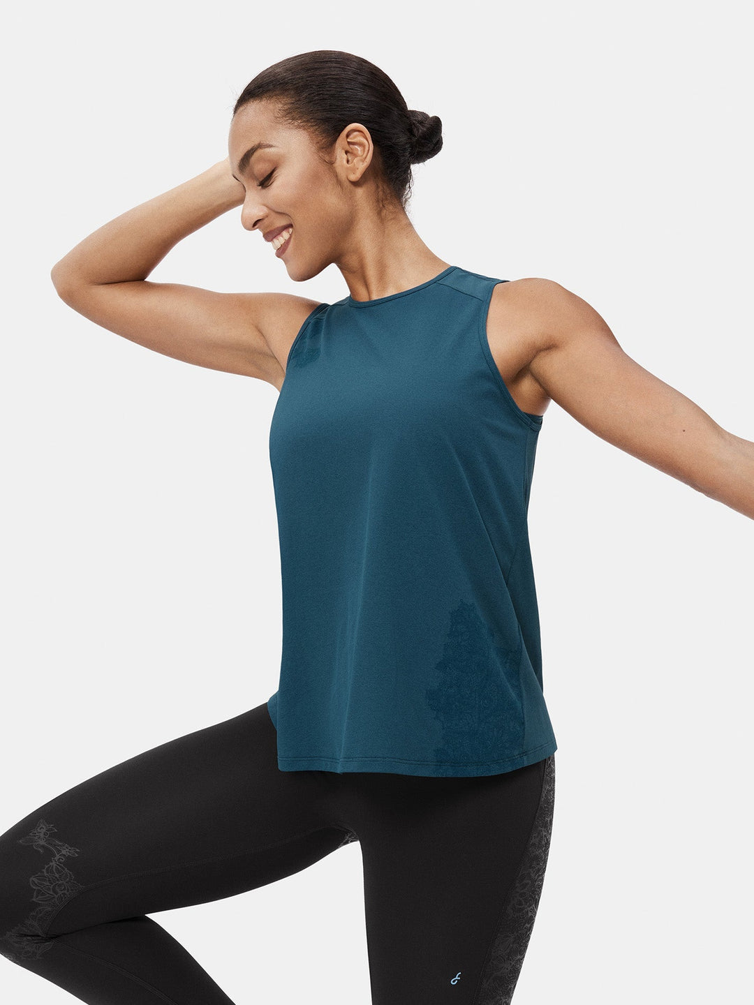 Woman wearing blue relaxed fit training sports vest with activewear leggings