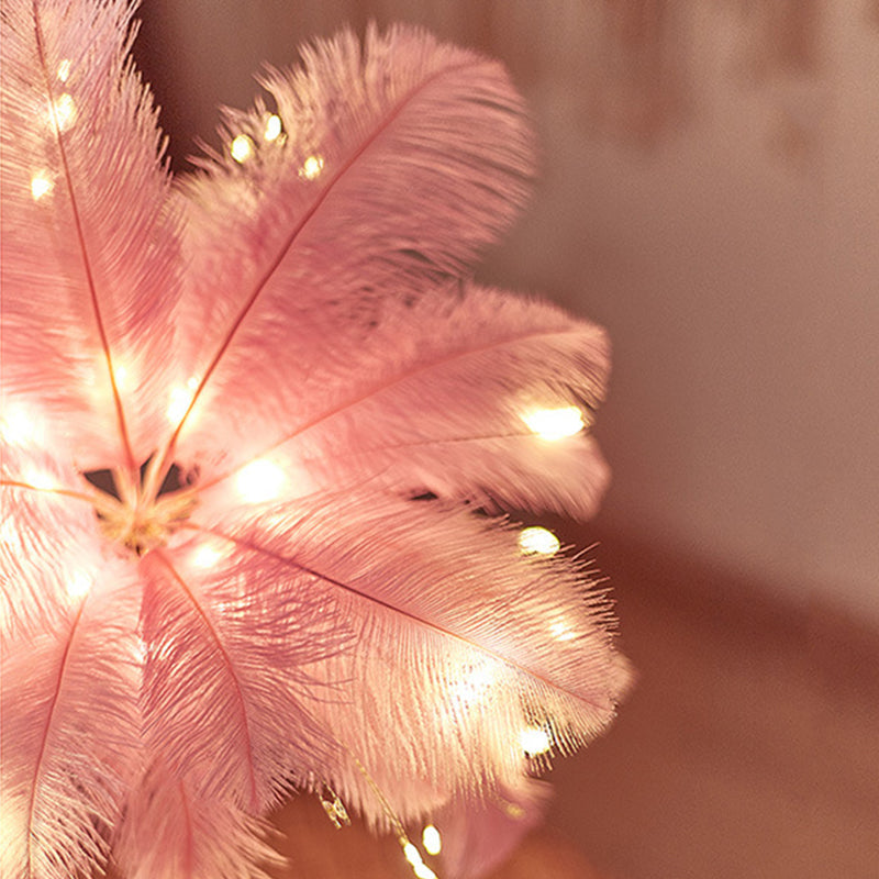 Aesthetic bedroom lighting accessory with fluffy feathers and a chic metallic base