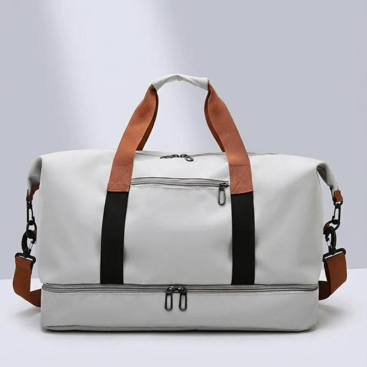 Front view of the spacious grey sports and travel bag featuring sturdy brown handles