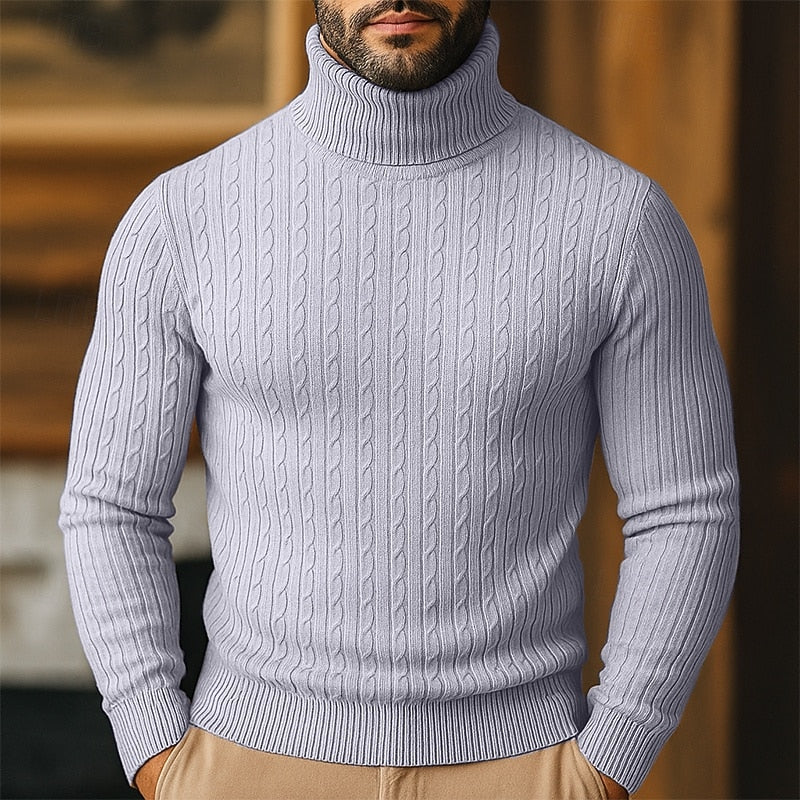 Man wearing a light grey cable-knit turtleneck jumper