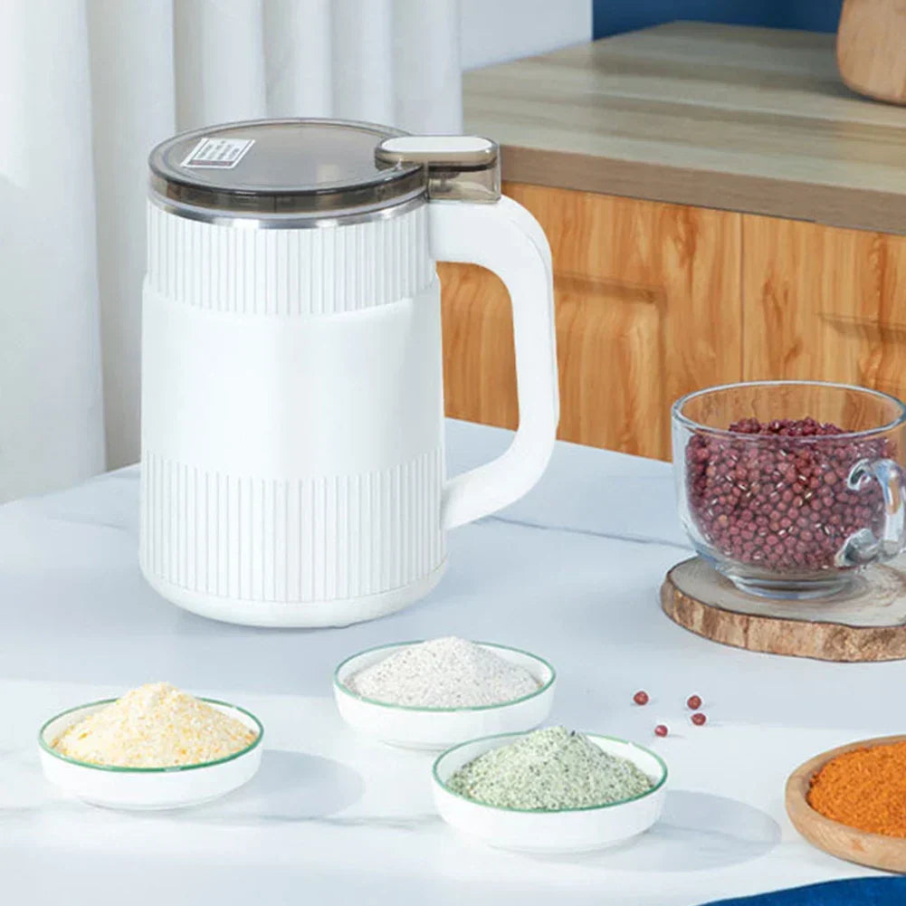 White compact electric spice grinder displayed with small bowls of ingredients