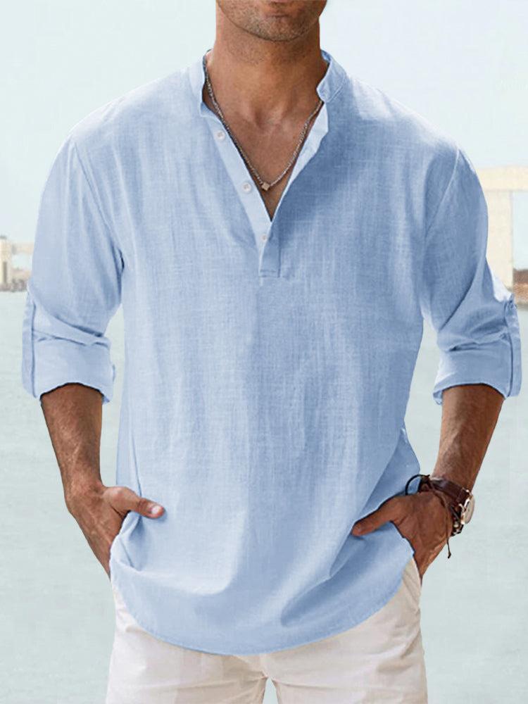 Man wearing a light blue button-up shirt in a casual outdoor setting