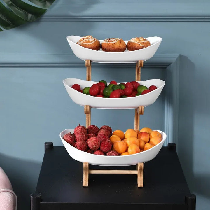 White three-tier fruit bowl display set with fresh fruit and baked goods