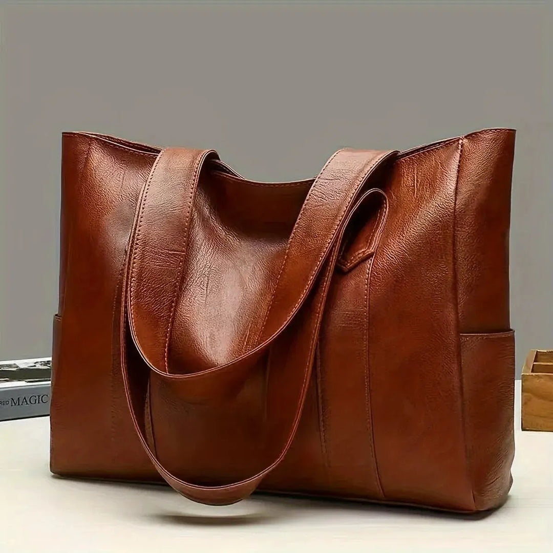 Coffee brown women's shoulder bag displayed on a table