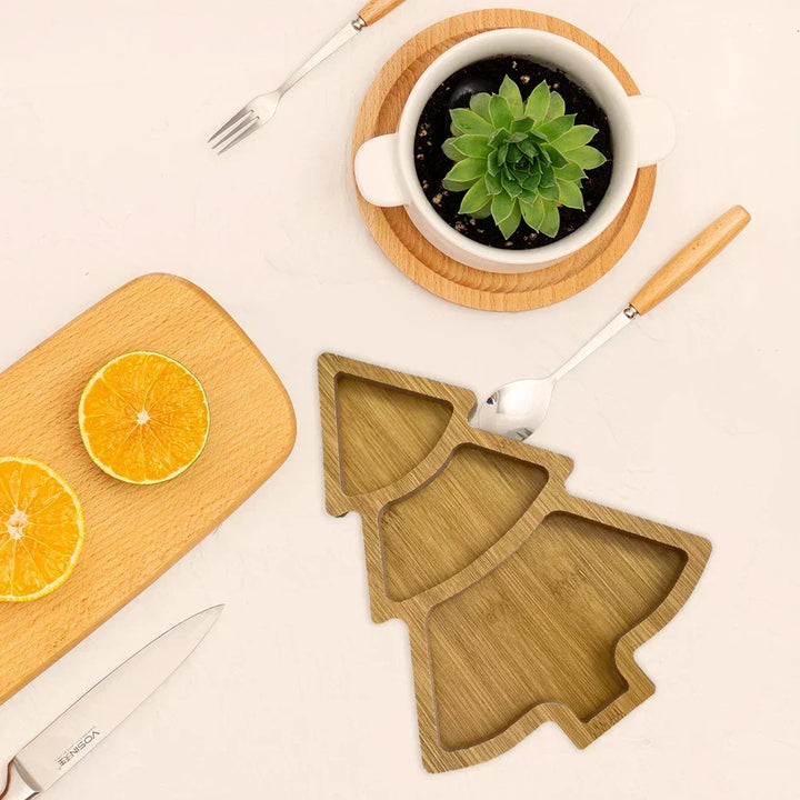 Christmas tree wooden serving board styled with holiday appetizers on a festive dining table