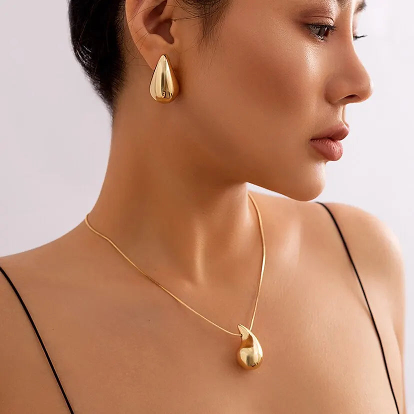 Close-up profile of a woman wearing the gold peapod earrings and choker necklace set