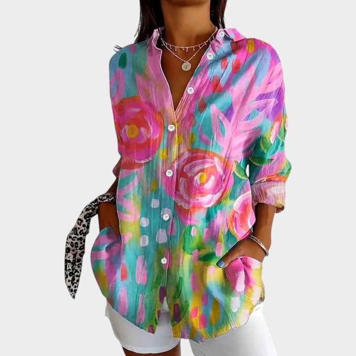 Woman wearing a pink botanical floral print button-up blouse with front pockets