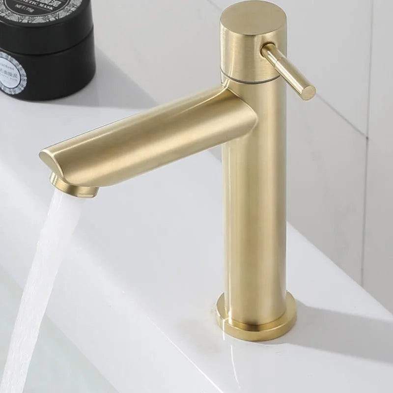 Gold stainless steel basin faucet operating on a white vanity
