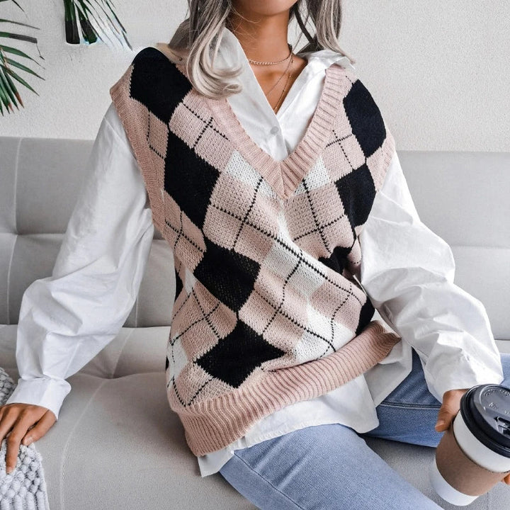 Woman sitting while wearing pink and black checked knit vest