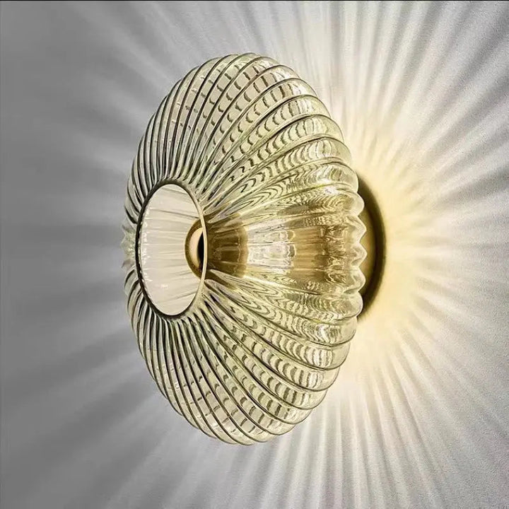 Nordic glass wall lamp in cognac finish mounted on a textured grey wall
