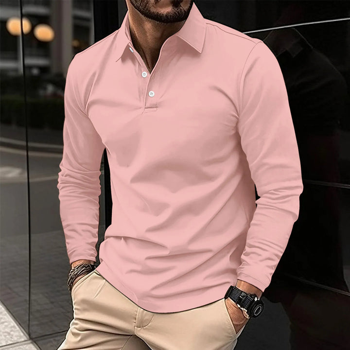 Man wearing pink long-sleeved polo shirt with khaki trousers