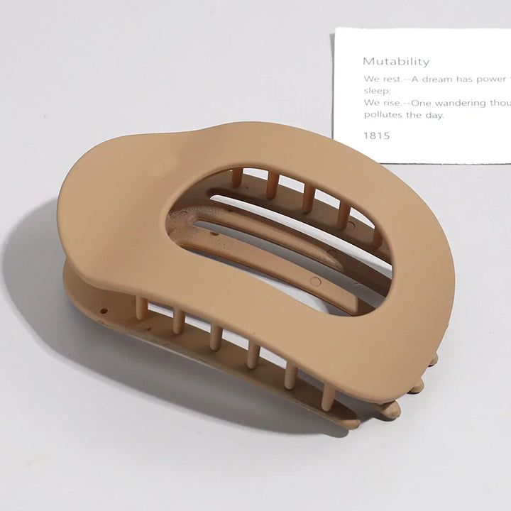 Tortoiseshell flat oval hair claw clip displayed on a neutral background