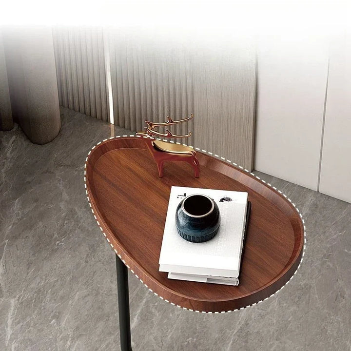 C-shaped mobile side table sliding over a living room sofa for easy laptop work
