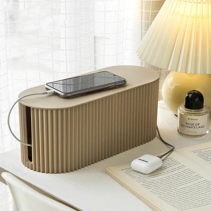 Green cable storage box on a desk for tidy home office cord management.