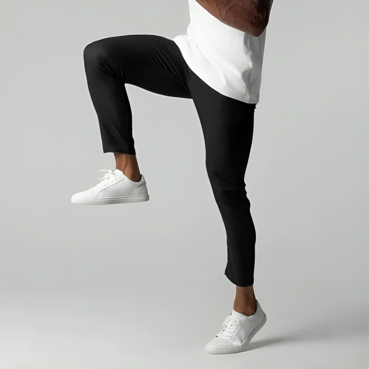Man demonstrating flexibility in black stretch chino trousers