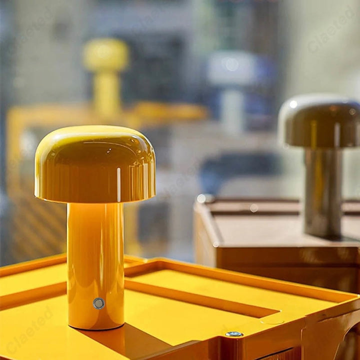 A yellow wireless retro LED table lamp showcased on a yellow surface with blurred background.