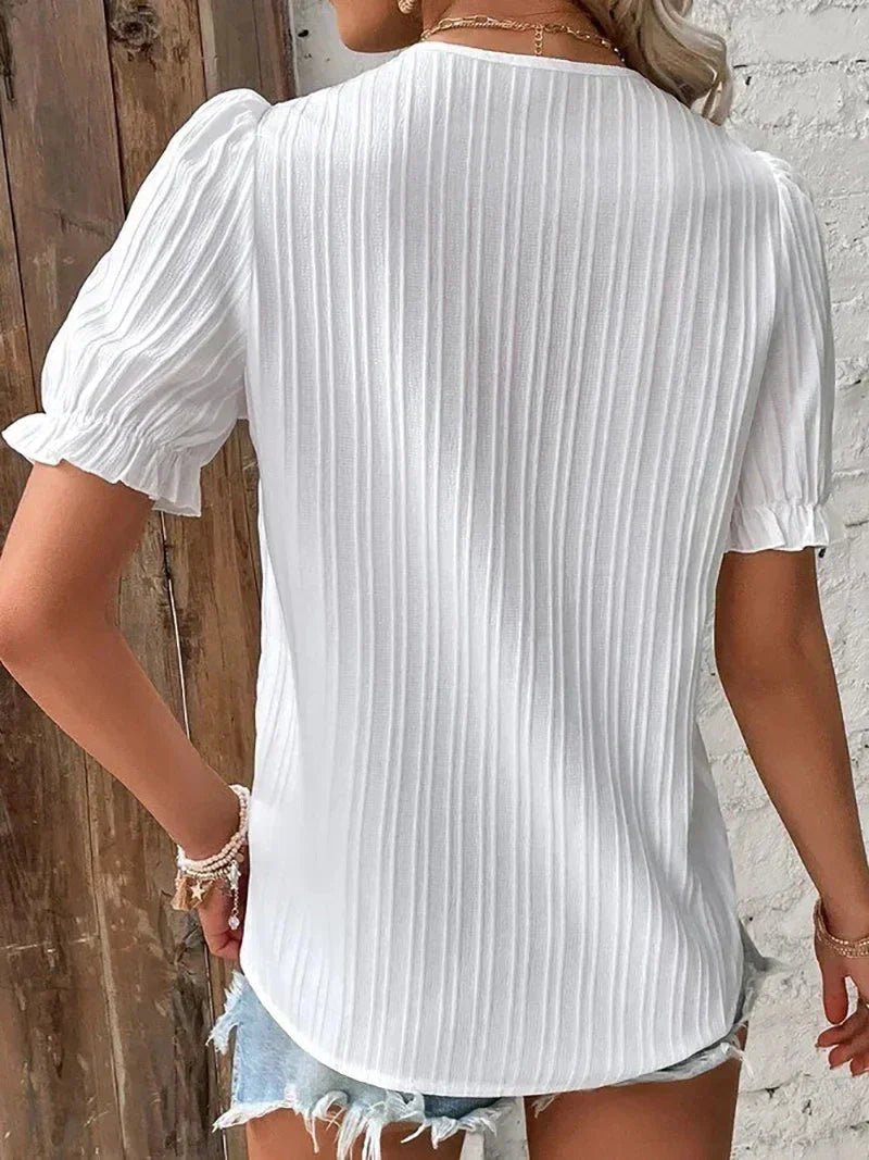Back view of the white short-sleeve Bea blouse showing draped fabric