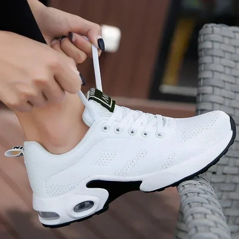 Close-up of hands tying the laces of white orthopaedic trainers