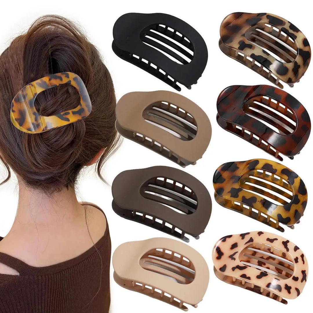 Woman wearing a tortoiseshell flat oval hair claw clip holding a secure updo bun