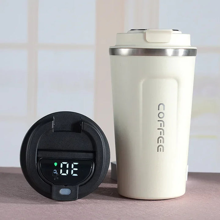 Close-up view of a cream-colored thermal mug next to its digital temperature display lid