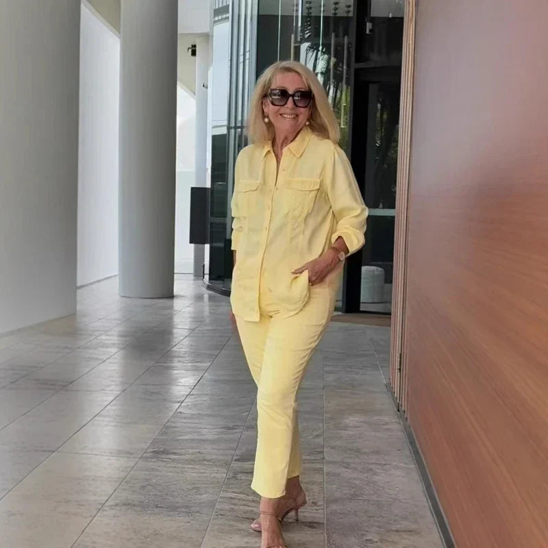 Woman wearing a bright yellow two-piece matching shirt and pants set with heels