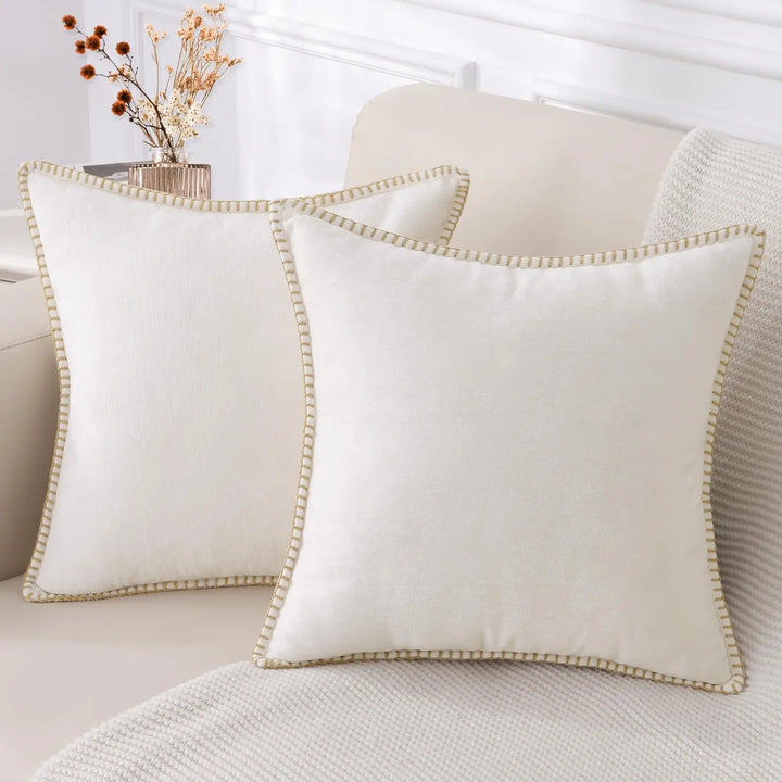 Cream white chenille cushion covers with stitched edge on a sofa