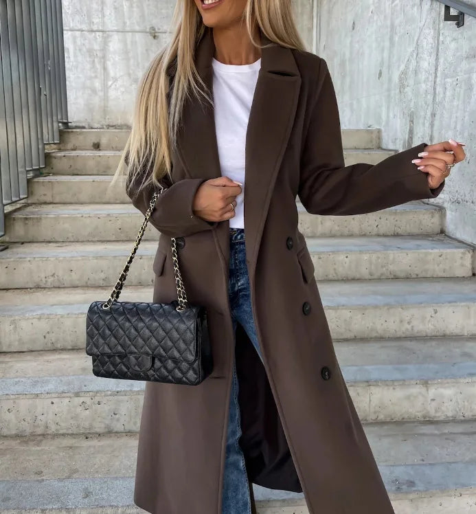 Woman wearing dark brown long lapel winter coat with a black handbag