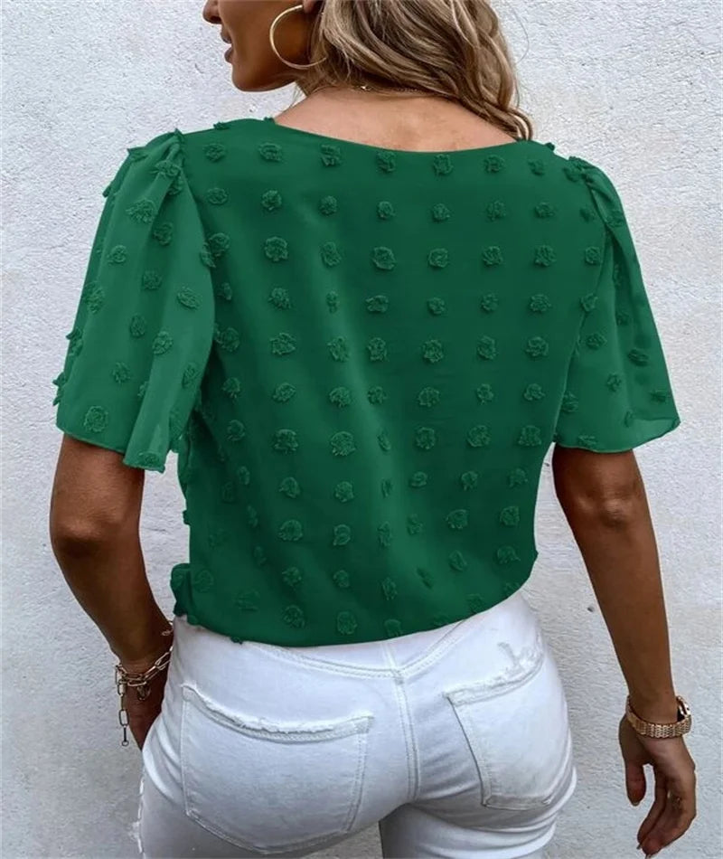 Close-up of the textured 3D floral appliques on a semi-fitted pink top