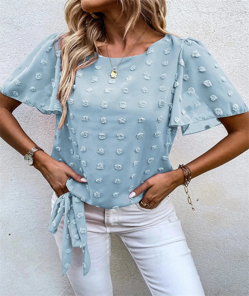 Woman wearing light blue Beatriz blouse featuring delicate textured appliqués